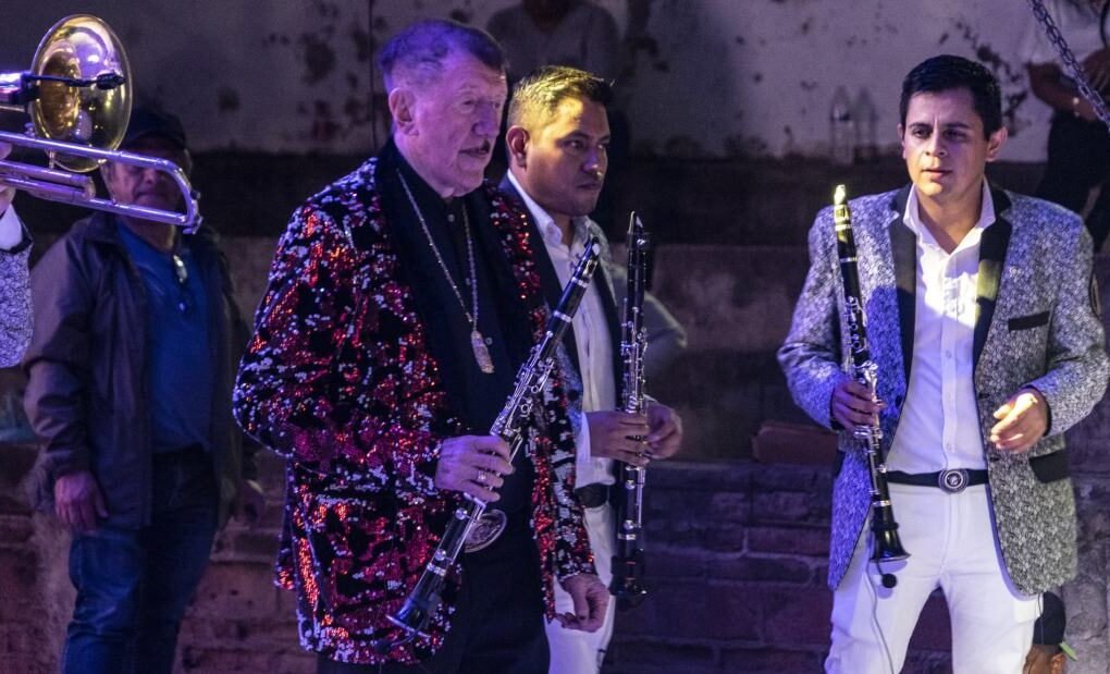 Germán Lizárraga tocando clarinete en un escenario con Banda Estrellas de Sinaloa.