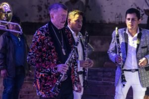 Germán Lizárraga tocando clarinete en un escenario con Banda Estrellas de Sinaloa.