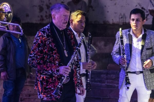 Germán Lizárraga tocando clarinete en un escenario con Banda Estrellas de Sinaloa.