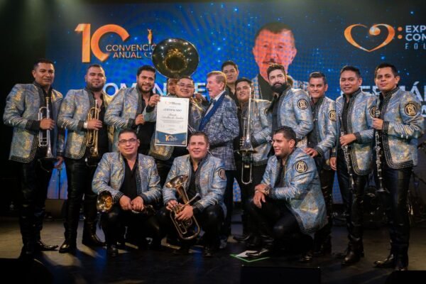 Germán Lizárraga de pie en el escenario del Lunario del Auditorio Nacional, sosteniendo un reconocimiento honorífico, rodeado de aplausos durante su homenaje en Expo Compositores 2025.
