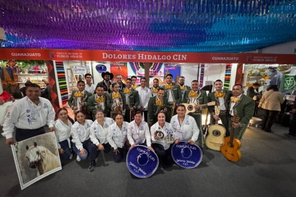 Los Gavilanes de José Alfredo Jiménez posan junto a Ángel Jiménez y autoridades turísticas en el stand de Dolores Hidalgo durante el Tianguis Nacional de Pueblos Mágicos.