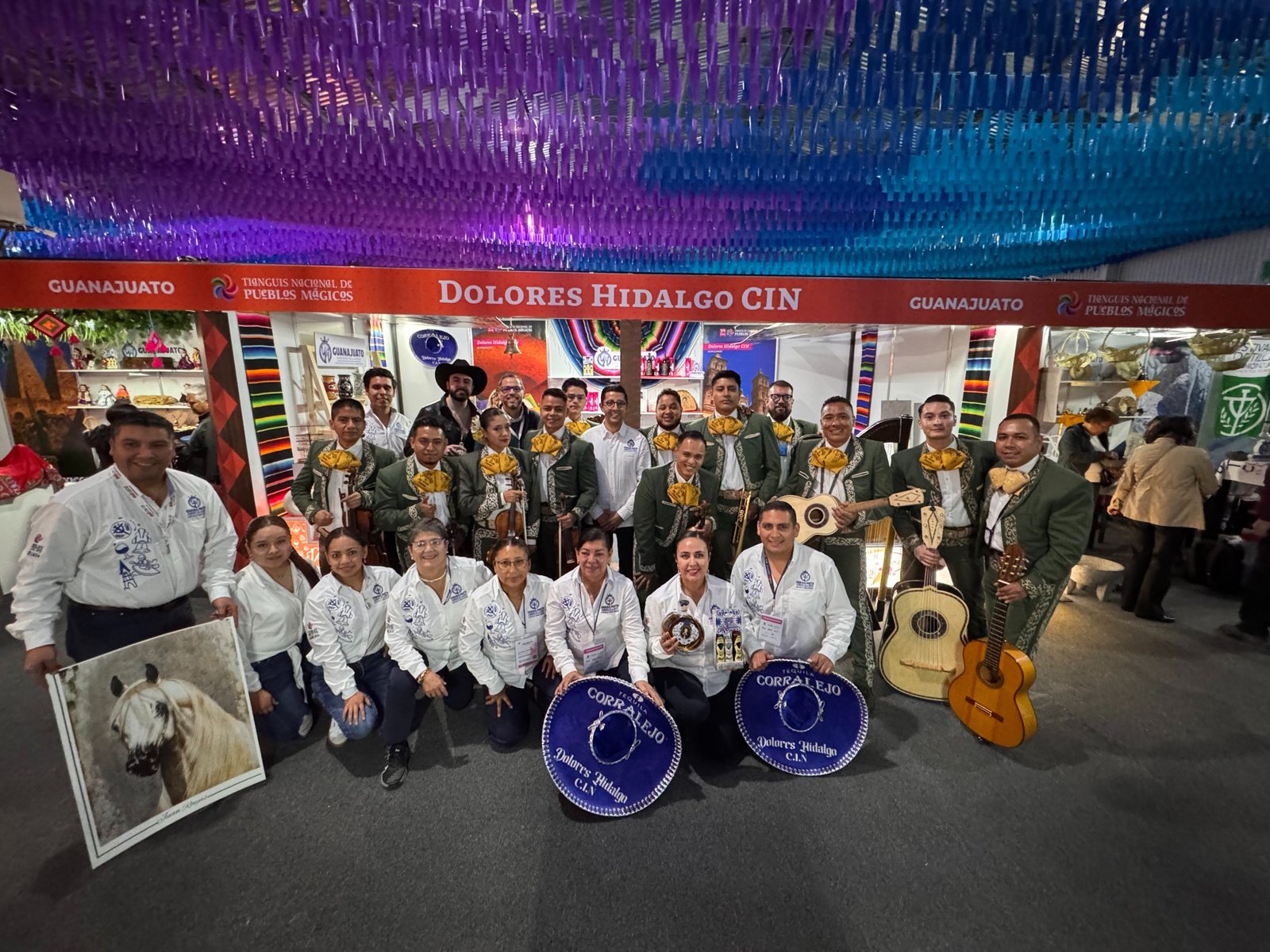 Los Gavilanes de José Alfredo Jiménez posan junto a Ángel Jiménez y autoridades turísticas en el stand de Dolores Hidalgo durante el Tianguis Nacional de Pueblos Mágicos.