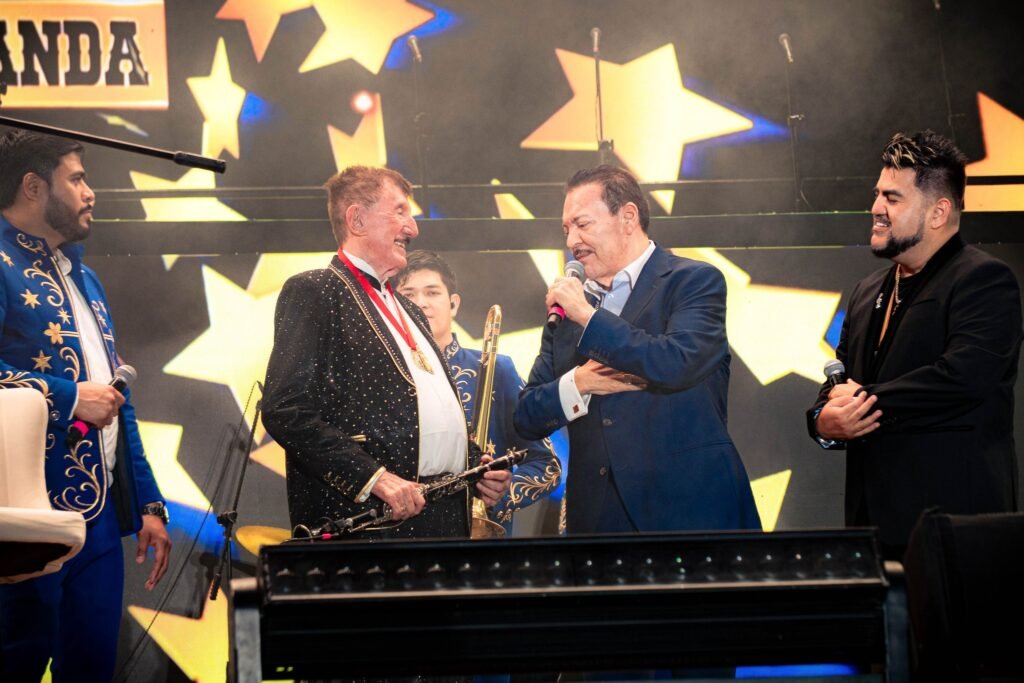 Germán Lizárraga acompañado por Julio Preciado en el escenario del Estadio Teodoro Mariscal durante el homenaje por sus 75 años de trayectoria.